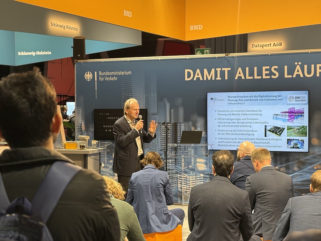 Am Stand von BIM Deutschland wird eine PowerPoint Präsentation gezeigt und von einem Mann moderiert. Das Publikum ist gut besucht.