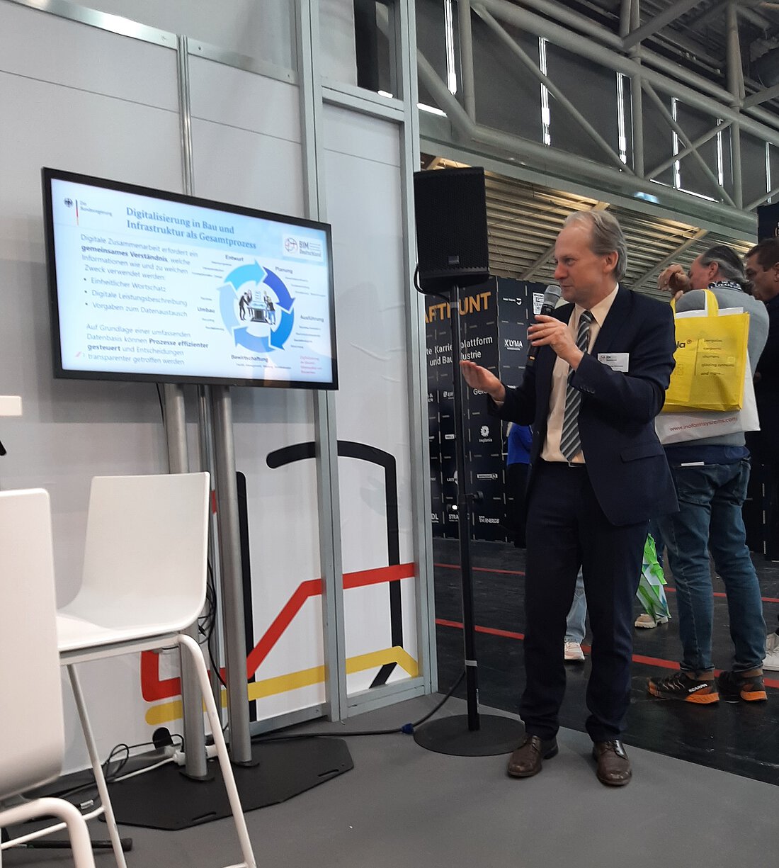 Dr. Christian Schlosser (BMDV) zeigt eine Präsentation und spricht in ein Mikrofon.